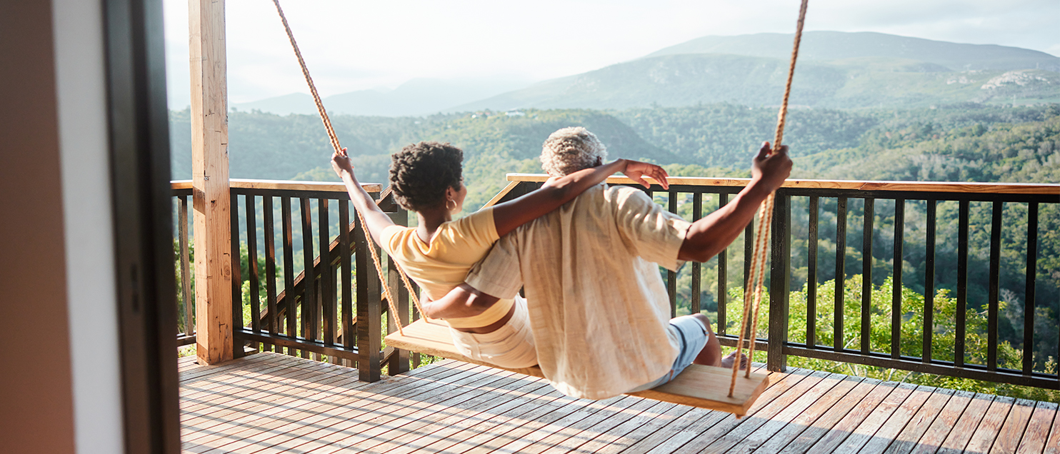 couple sitting on swing looking at the mountains